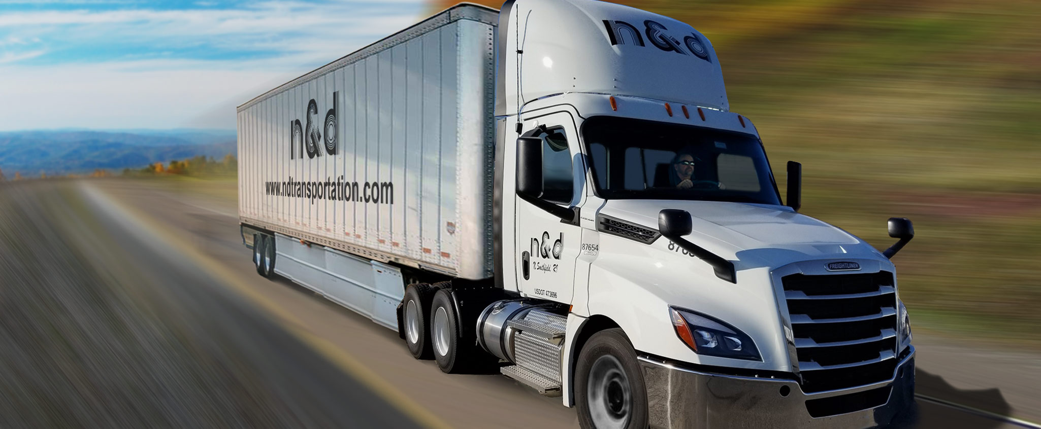 Man driving a white 18 wheel truck down a highway