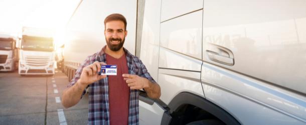 Man holding CDL drivers license in front of truck in rhode island