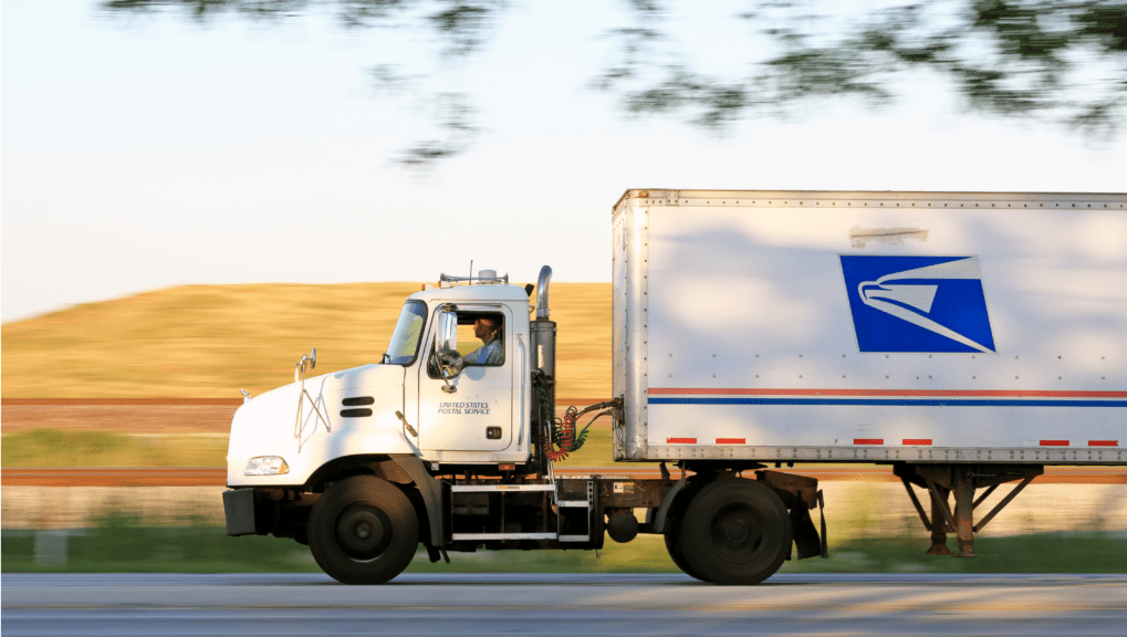 United States Postal Service truck running an expedited shipping delivery while speeding down the highway
