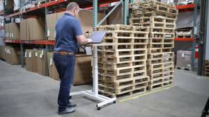 a Rhode Island warehouse worker standing at a computer looking up inventory at New Englands best warehouse and warehousing facility