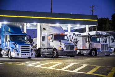 3 heavy haulers lined up under canopy looking for trucking jobs to take a northeast trucking company freight to destination