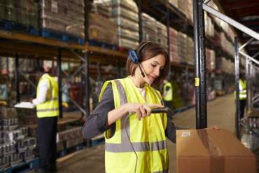 a rhode island warehouse worker using a warehouse management system to organize warehouse inventory