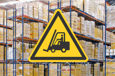 warning sign in front of stacked pallets in a warehouse signifying warehouse safety