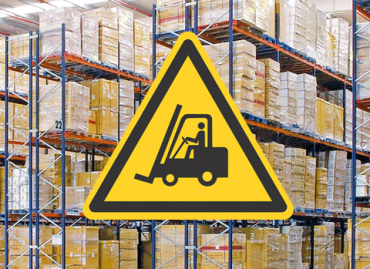 warning sign in front of stacked pallets in a warehouse signifying warehouse safety