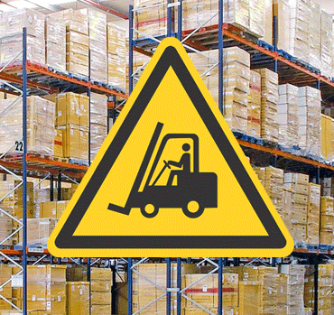 warning sign in front of stacked pallets in a warehouse signifying warehouse safety