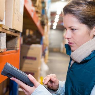 a woman holding a scanner up to a box in a warehouse in Rhode Island
