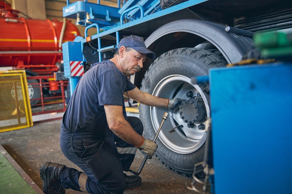 mechanic working on trucking tires showing challenges in logistics