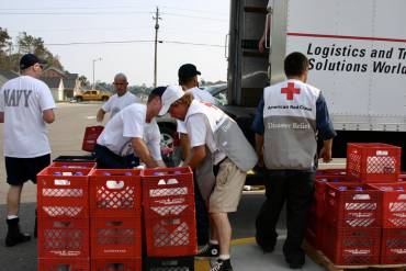 red cross disaster logistics truck being loaded by a group of volunteers