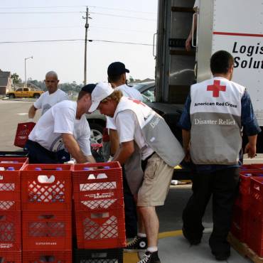 red cross disaster logistics truck being loaded by a group of volunteers