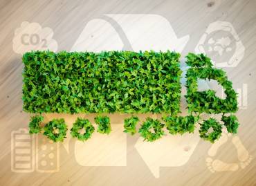 Green truck with recycle logo behind it signifying sustainable trucking practices