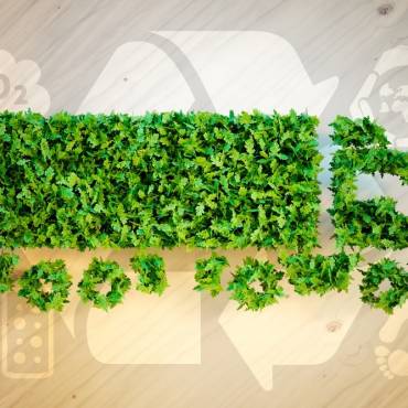 Green truck with recycle logo behind it signifying sustainable trucking practices