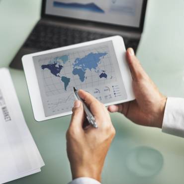 Nearshoring image with people holding a tablet and pointing to transportation ports